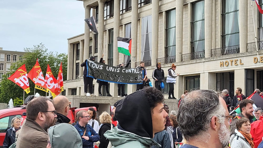 Manifestant·e·s tenant une banderole indiquant "Tous unis contre l’extrême droite" devant l’hôtel de ville du Havre